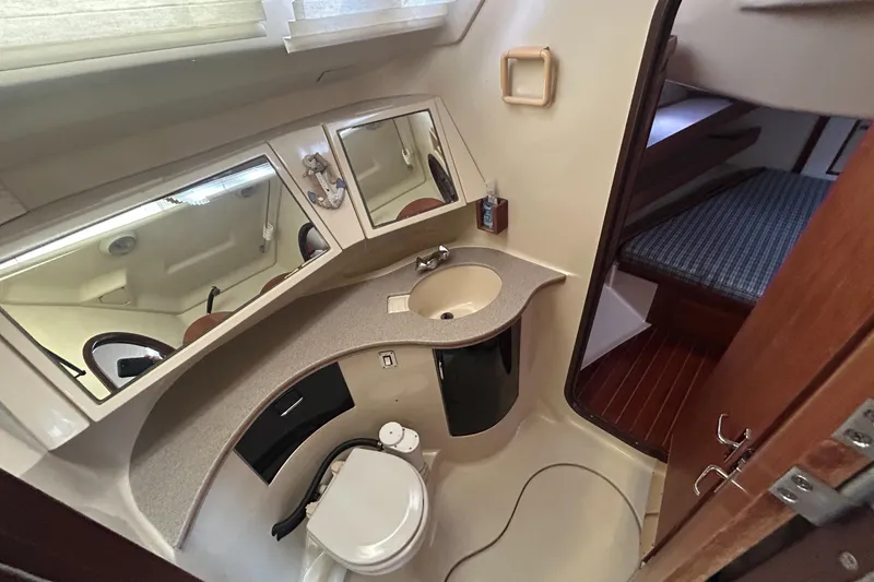 Slide: The Image of 1994 Hunter Legend 40.5 yacht bathroom with sink, toilet, and mirrors. - 13