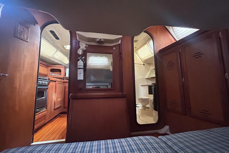 Slide: The Image of Interior of 1994 Hunter Legend 40.5 sailboat, featuring wood cabinetry and compact kitchen. - 14