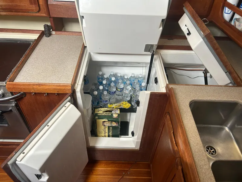 Slide: The Image of 1994 Hunter Legend 40.5 yacht kitchen with open fridge, water bottles, and ale. - 9