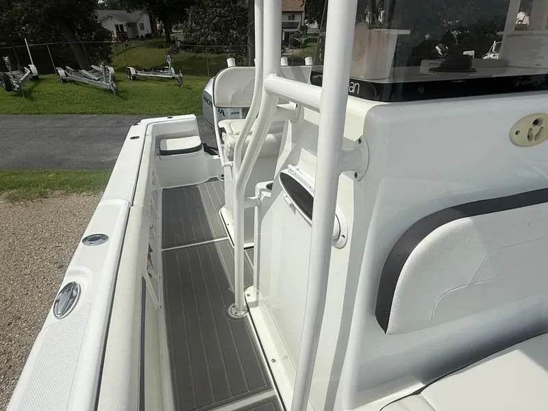 Slide: The Image of 2018 Clearwater 2200CC boat interior with seating and console, parked outdoors. - 16