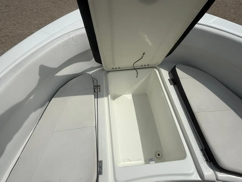 Slide: The Image of Open storage compartment on 2018 Clearwater 2200CC boat, featuring cushioned seating. - 19