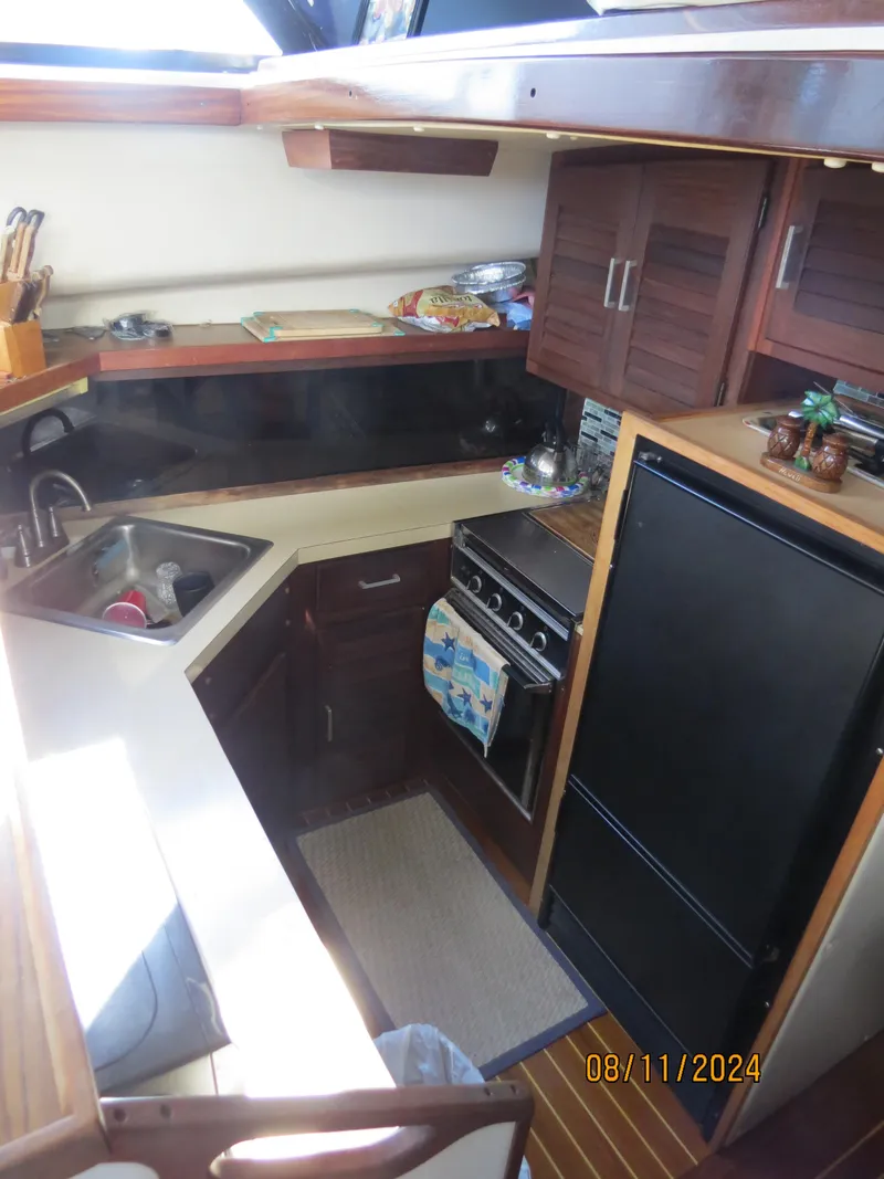 Slide: The Image of 1983 Silverton 40 Aft Cabin kitchen with sink, stove, and refrigerator. - 14