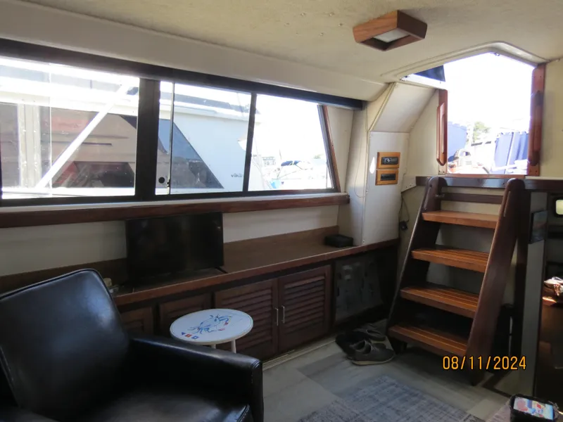 Slide: The Image of 1983 Silverton 40 Aft Cabin interior with stairs, window, and seating area. - 15