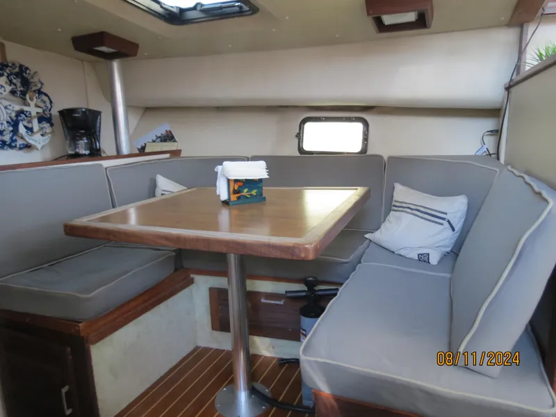 Slide: The Image of 1983 Silverton 40 Aft Cabin interior with dining area and cushioned seating. - 17