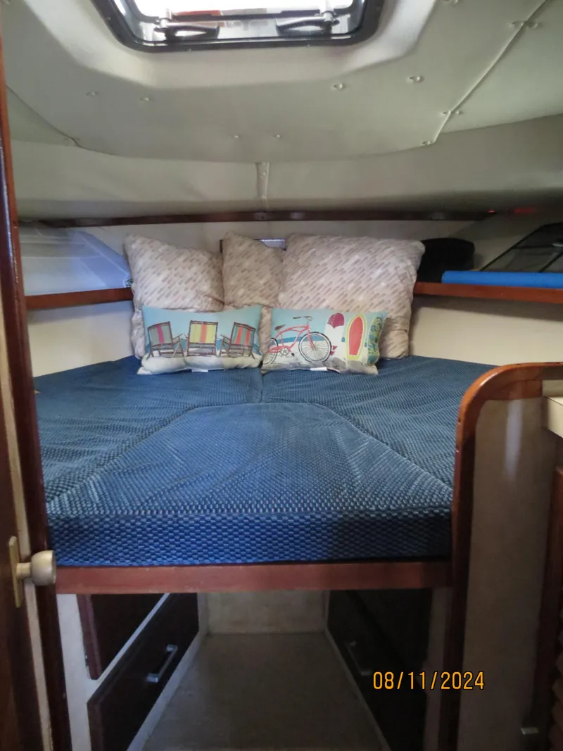 Slide: The Image of 1983 Silverton 40 Aft Cabin interior with cozy bedding and decorative pillows. - 18