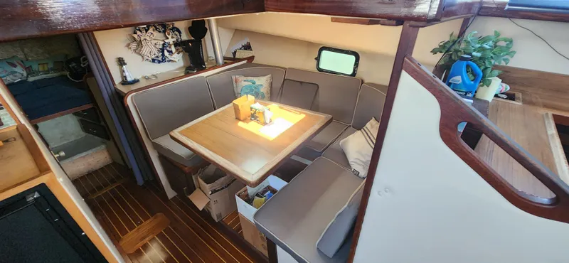 Slide: The Image of 1983 Silverton 40 Aft Cabin interior with cozy dining area and wooden accents. - 21
