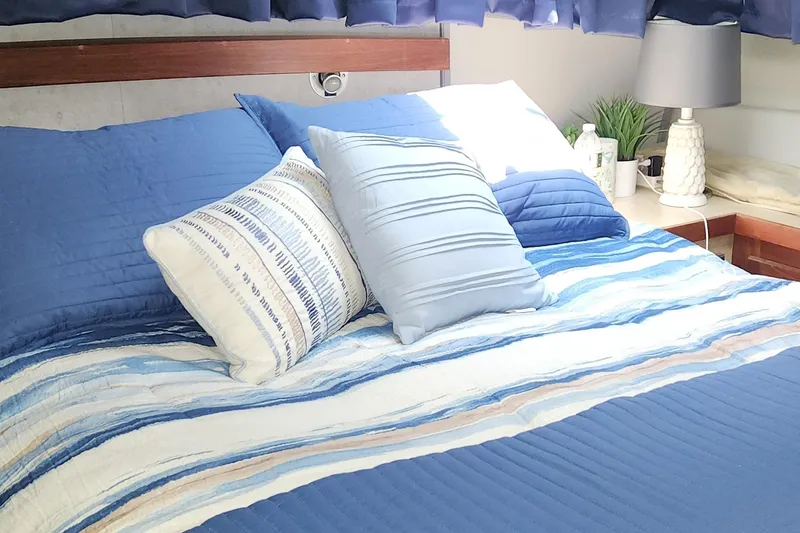Slide: The Image of Cozy bedroom in 1983 Silverton 40 Aft Cabin with blue bedding and decorative pillows. - 23