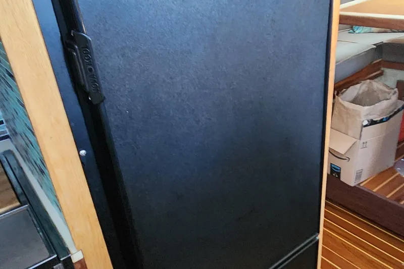 Slide: The Image of 1983 Silverton 40 Aft Cabin interior with black door and wooden flooring. - 27