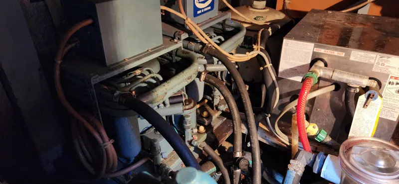 Slide: The Image of Engine room of a 1983 Silverton 40 Aft Cabin boat, showcasing complex piping and machinery. - 29