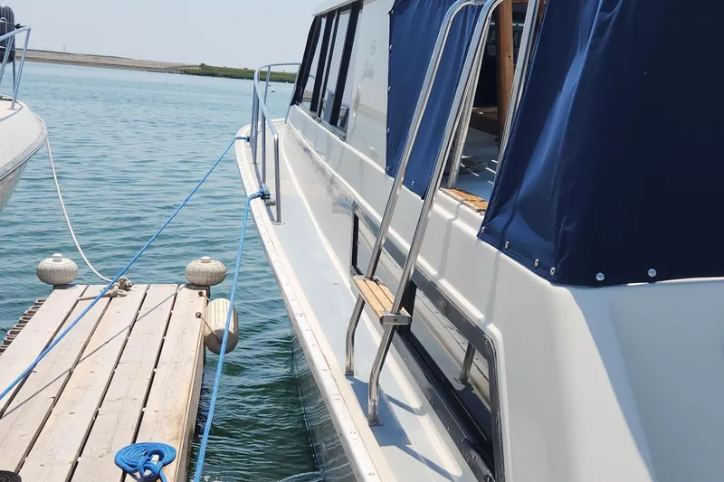 Slide: The Image of 1983 Silverton 40 Aft Cabin yacht docked with blue canopy. - 3