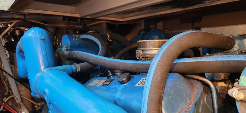 Slide: The Image of Engine compartment of a 1983 Silverton 40 Aft Cabin boat, featuring blue engine components. - 34