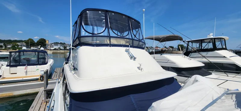 Slide: The Image of 1983 Silverton 40 Aft Cabin yacht docked at marina under clear blue sky. - 4
