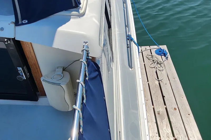 Slide: The Image of 1983 Silverton 40 Aft Cabin boat docked, showing deck and railing details. - 6