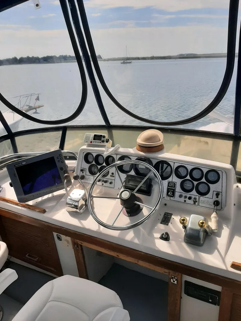 Slide: The Image of 1983 Silverton 40 Aft Cabin helm with steering wheel, gauges, and navigation equipment. - 8