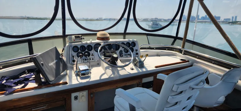 Slide: The Image of 1983 Silverton 40 Aft Cabin helm with steering wheel, controls, and panoramic water view. - 9