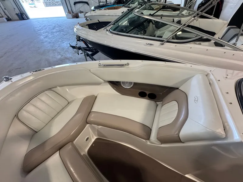 Slide: The Image of 2003 Regal 2200 boat interior with beige and white seating in a showroom. - 13