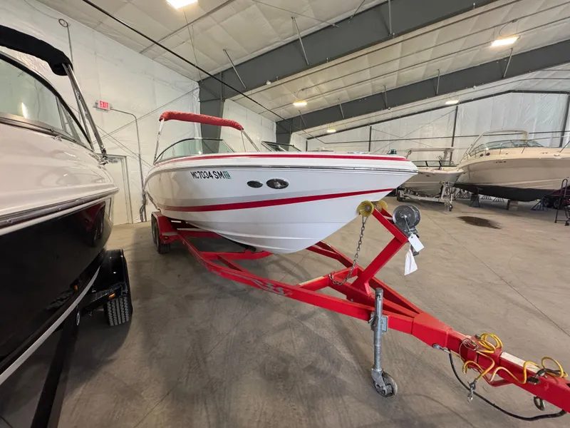 Slide: The Image of 2003 Regal 2200 boat on red trailer in indoor storage facility. - 2