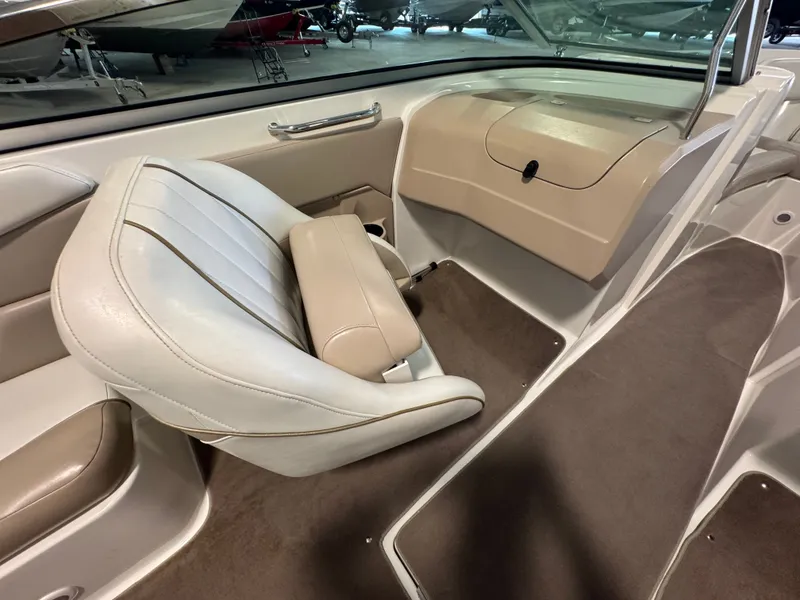 Slide: The Image of Interior of a 2003 Regal 2200 boat, featuring beige and white seating. - 7