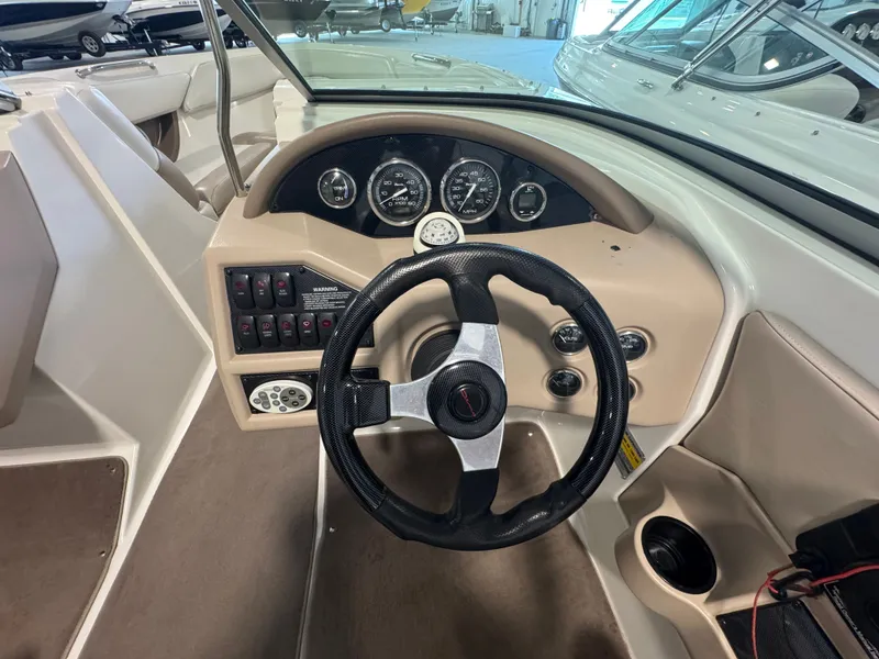 Slide: The Image of 2003 Regal 2200 boat dashboard with steering wheel and instrument panel. - 9