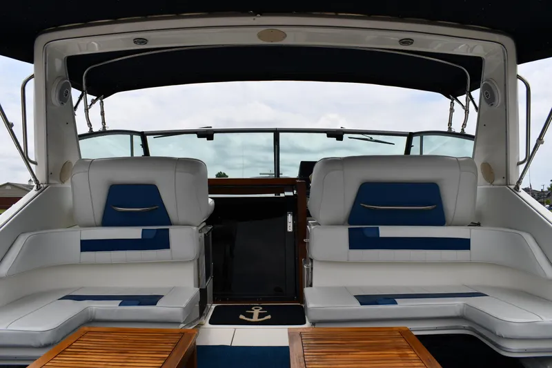 Slide: The Image of 1989 Sea Ray 390 Express Cruiser interior with white seating and wooden accents. - 10