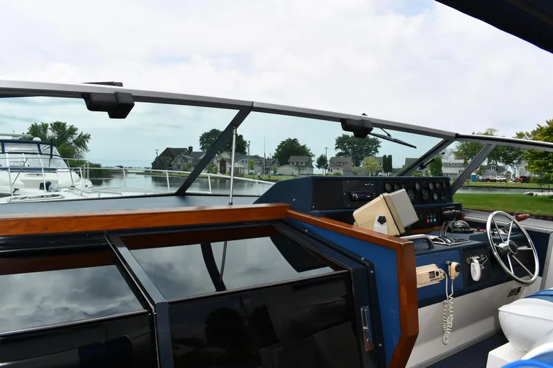 Slide: The Image of 1989 Sea Ray 390 Express Cruiser helm with view of marina and waterfront homes. - 11