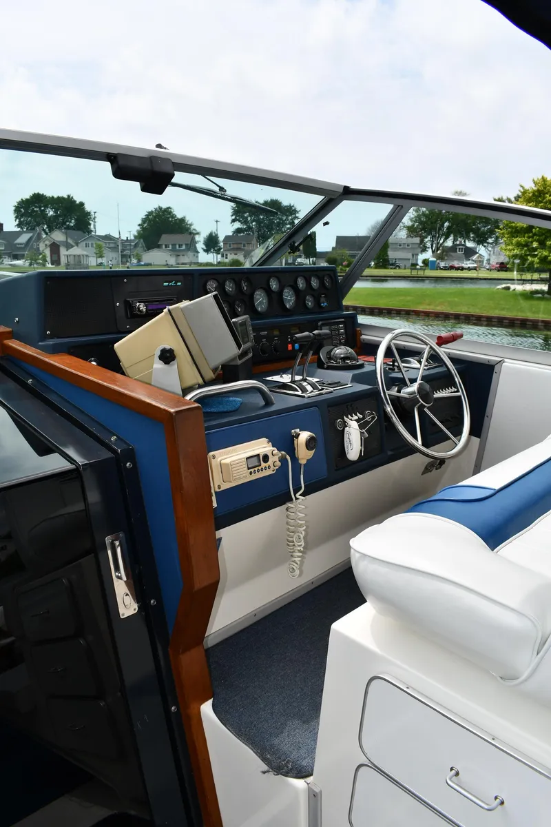 Slide: The Image of 1989 Sea Ray 390 Express Cruiser helm with steering wheel and control panel. - 13