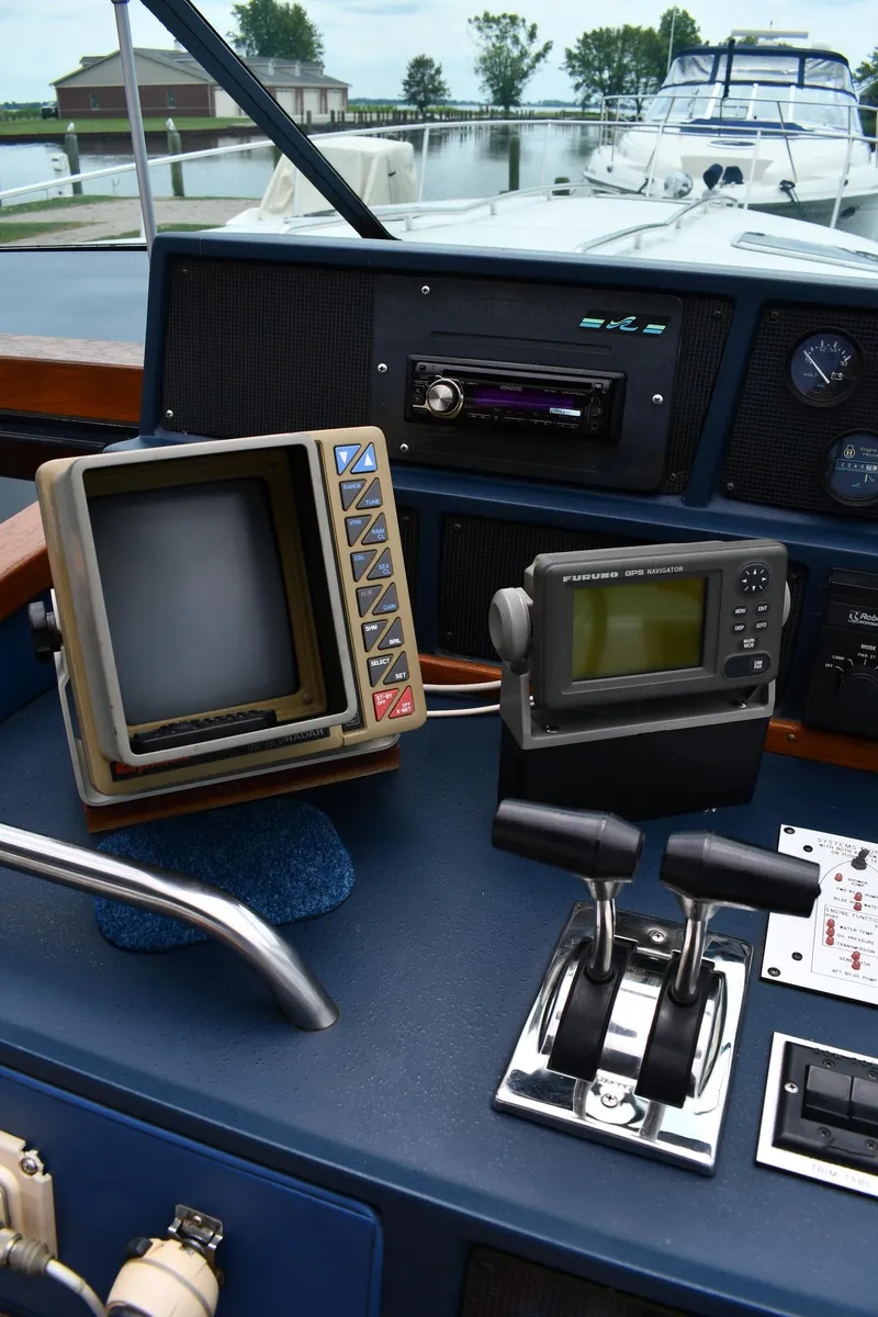 Slide: The Image of 1989 Sea Ray 390 Express Cruiser helm with vintage navigation equipment and controls. - 16