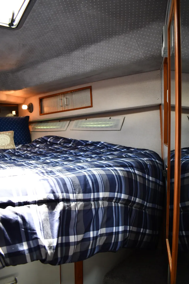 Slide: The Image of Interior cabin of 1989 Sea Ray 390 Express Cruiser with plaid bedding. - 33