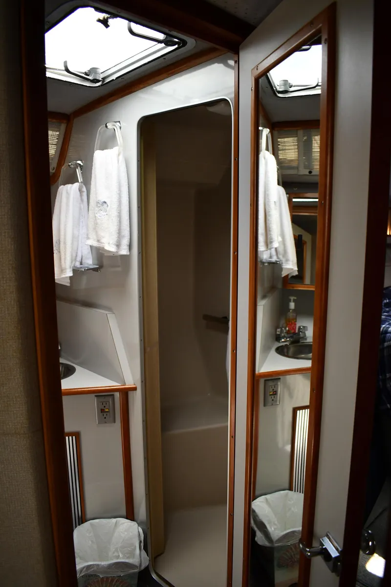 Slide: The Image of 1989 Sea Ray 390 Express Cruiser bathroom with mirrors, sink, and towels. - 38