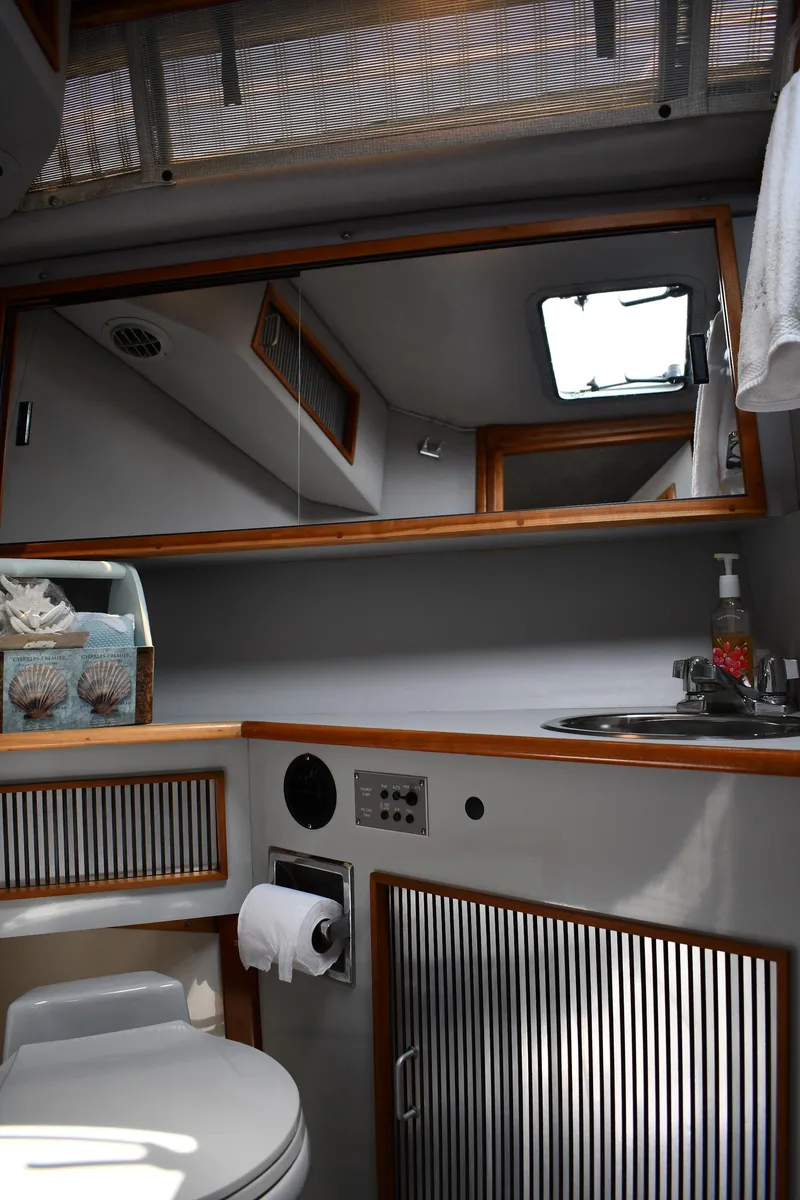 Slide: The Image of 1989 Sea Ray 390 Express Cruiser bathroom with mirror, sink, and toilet. - 39
