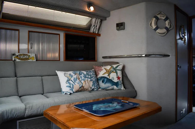 Slide: The Image of 1989 Sea Ray 390 Express Cruiser interior with cozy seating and nautical decor. - 41