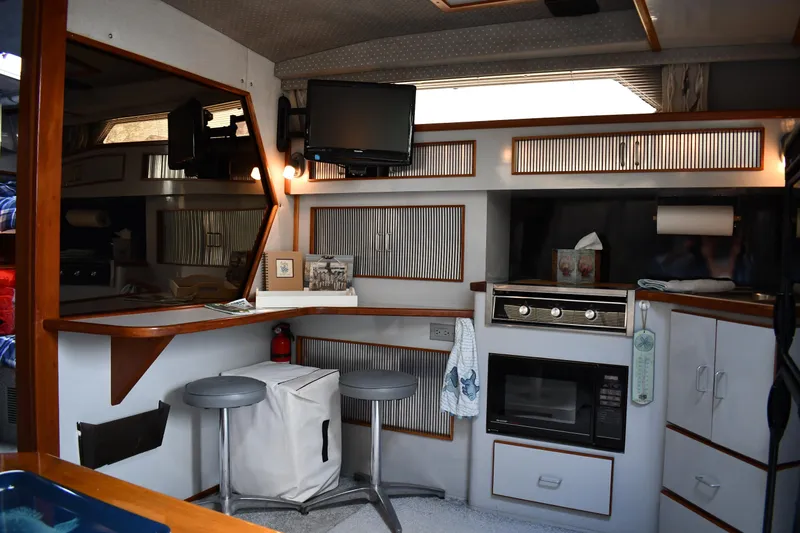 Slide: The Image of Interior of 1989 Sea Ray 390 Express Cruiser with kitchen and seating area. - 43