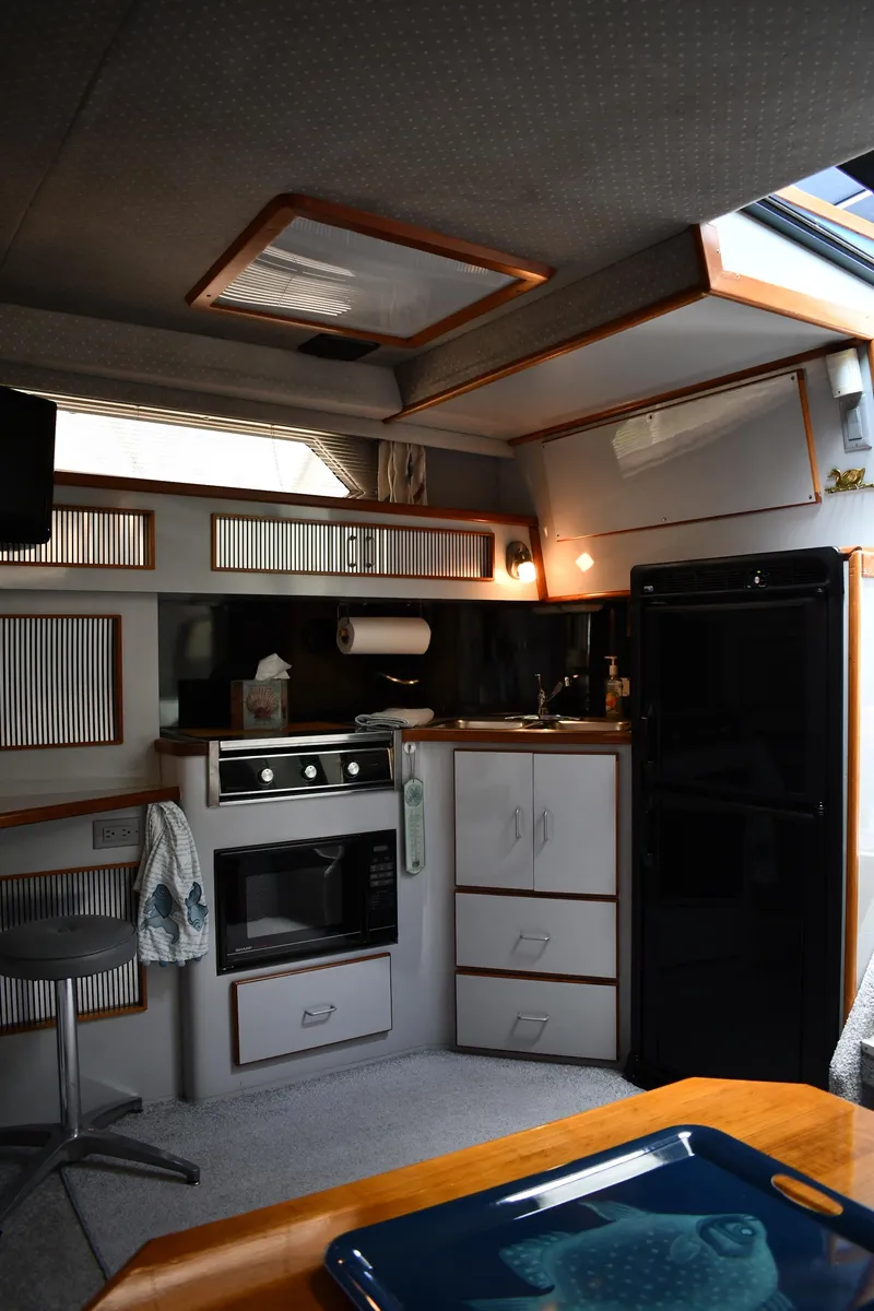 Slide: The Image of Interior of 1989 Sea Ray 390 Express Cruiser with kitchen and seating area. - 46