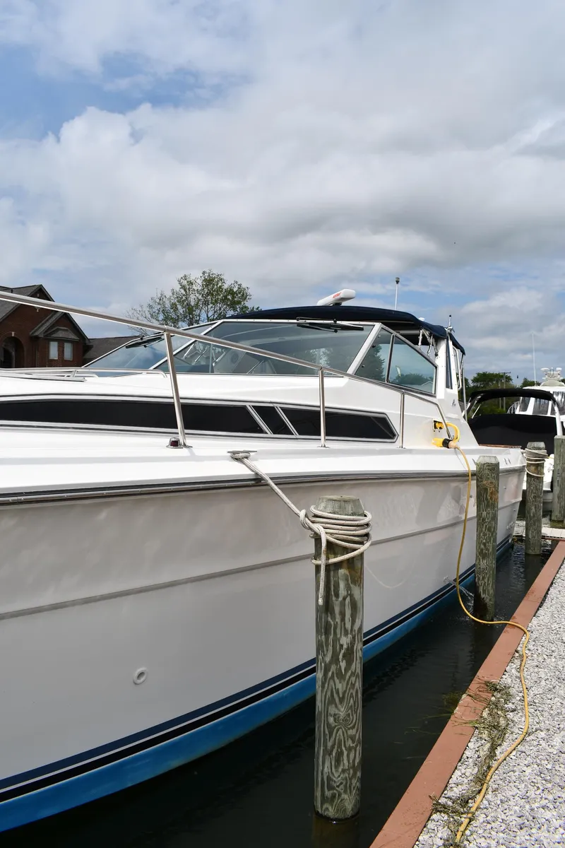 Slide: The Image of 1989 Sea Ray 390 Express Cruiser docked at marina under cloudy sky. - 5