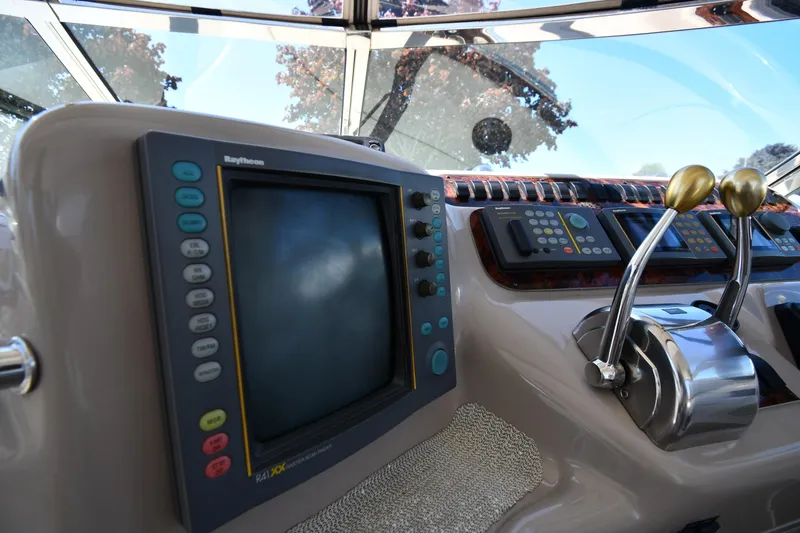 Slide: The Image of 1997 Sea Ray 400 Sundancer helm with navigation controls and throttle levers. - 15