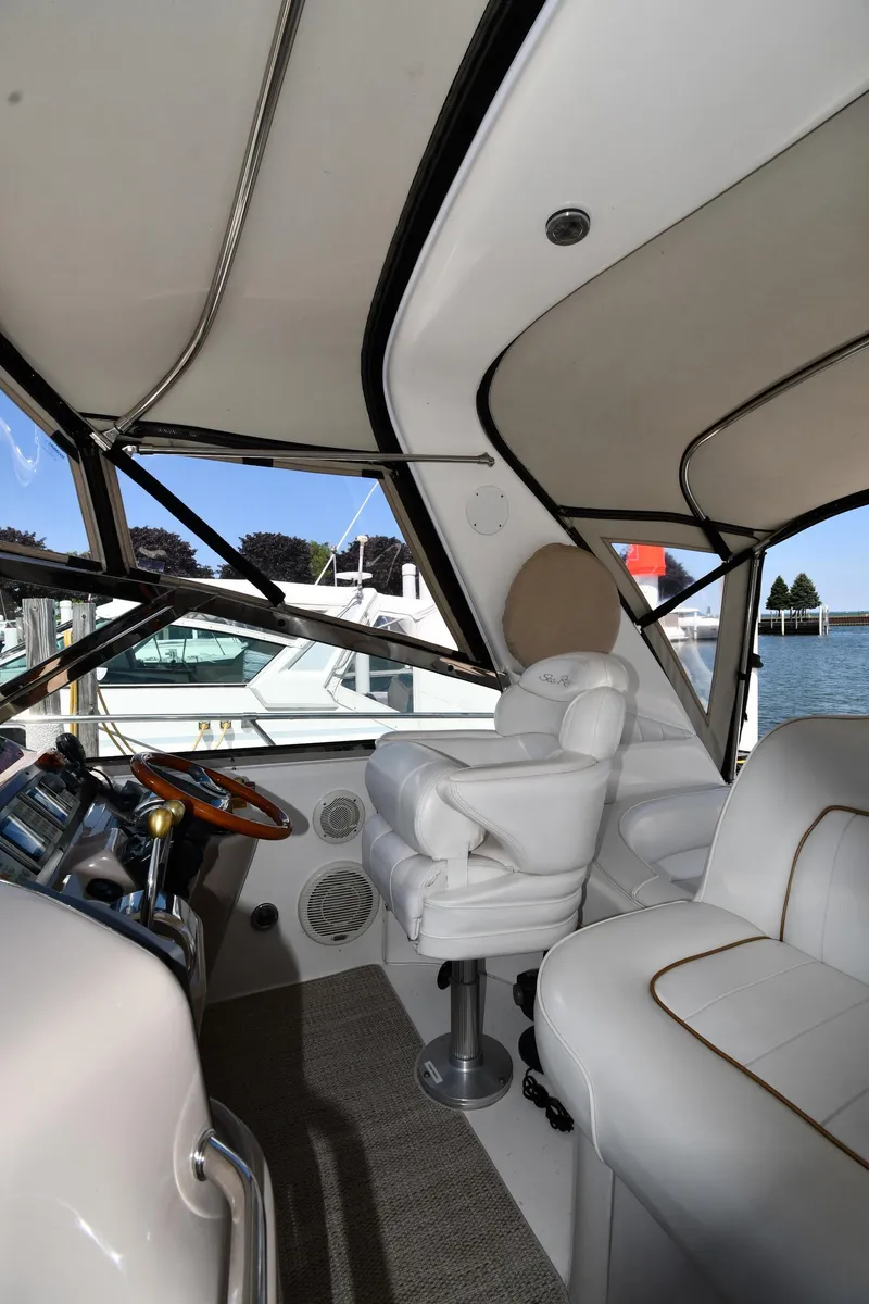 Slide: The Image of Interior view of 1997 Sea Ray 400 Sundancer yacht with white leather seating and helm. - 18