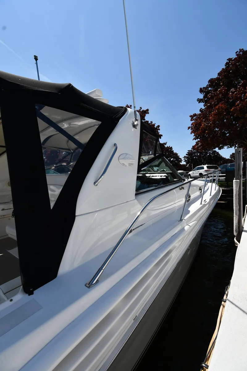 Slide: The Image of 1997 Sea Ray 400 Sundancer yacht docked, featuring sleek white exterior and black canopy. - 2