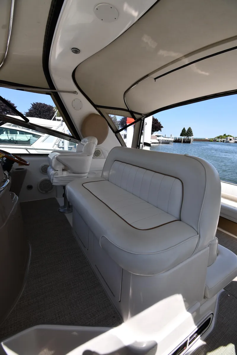 Slide: The Image of 1997 Sea Ray 400 Sundancer interior with white seating and waterfront view. - 20