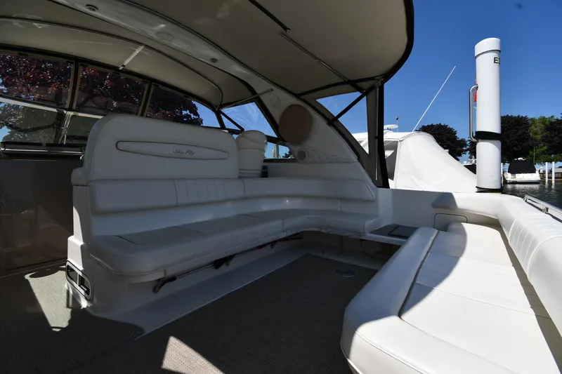 Slide: The Image of 1997 Sea Ray 400 Sundancer interior with white seating and canopy, docked at marina. - 21