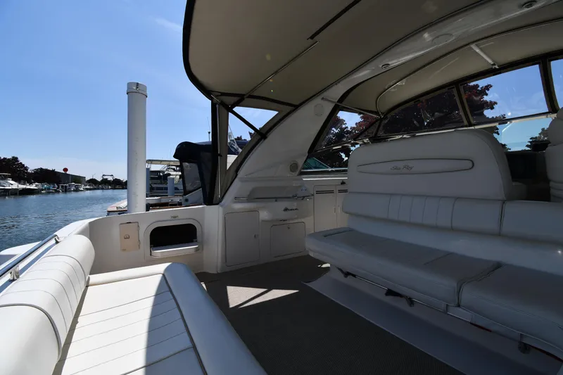 Slide: The Image of 1997 Sea Ray 400 Sundancer interior with white seating, docked by the water. - 23