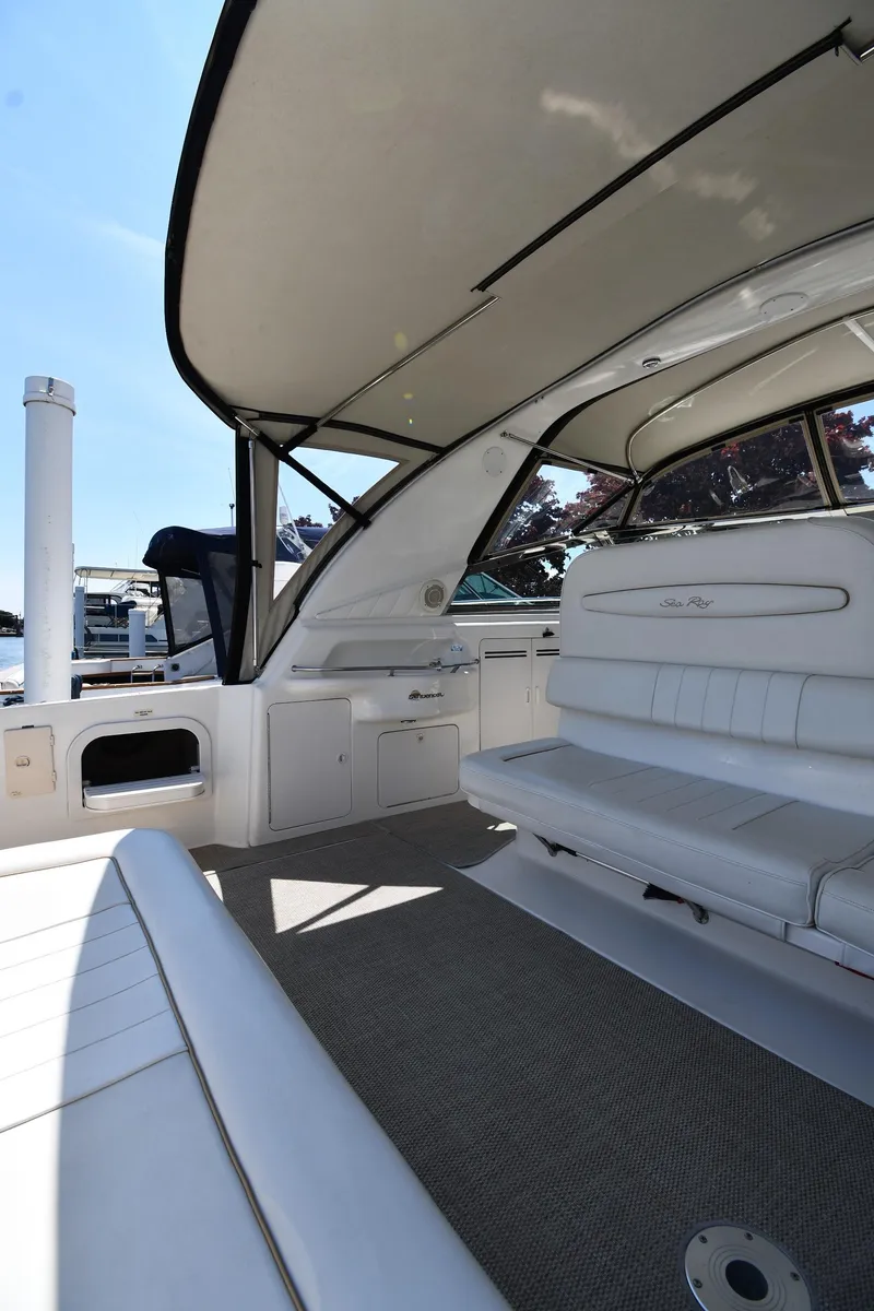 Slide: The Image of 1997 Sea Ray 400 Sundancer interior with white seating and spacious deck area. - 24