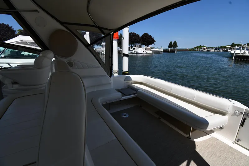 Slide: The Image of 1997 Sea Ray 400 Sundancer yacht interior with waterfront view, featuring white seating and sleek design. - 25