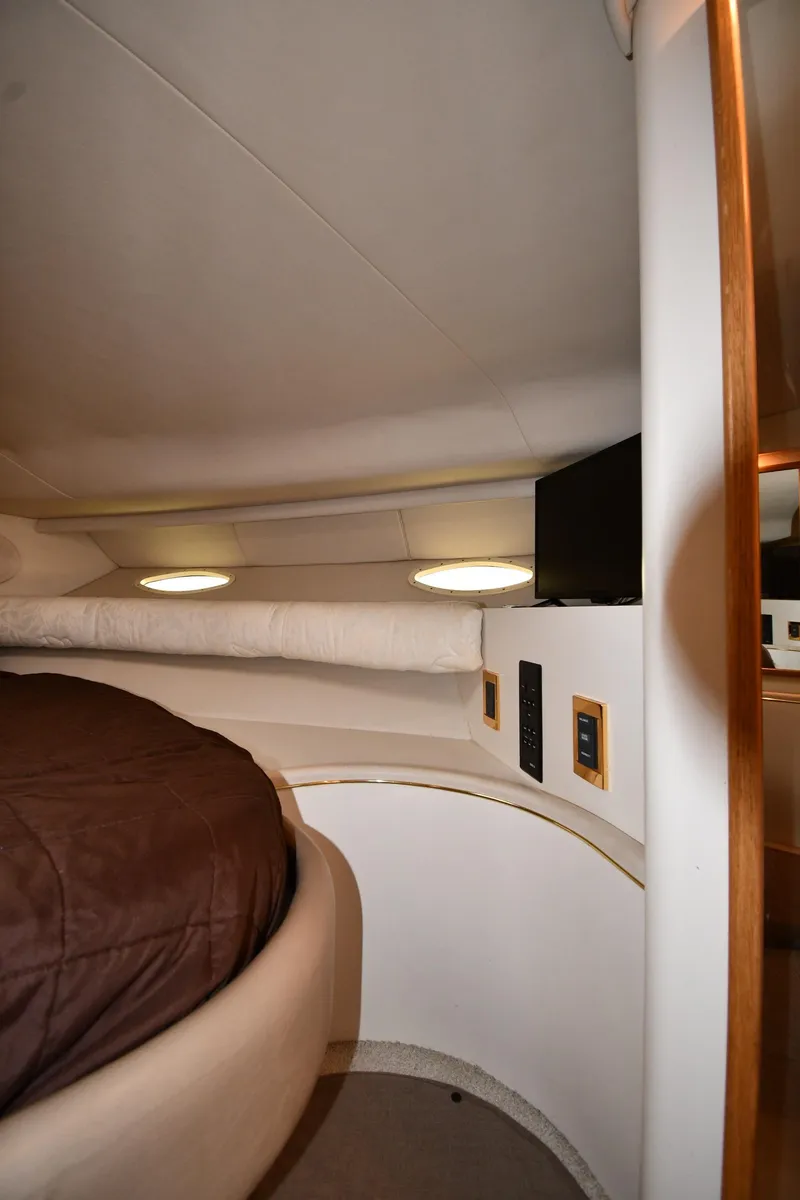 Slide: The Image of 1997 Sea Ray 400 Sundancer cabin interior with bed, portholes, and TV. - 32