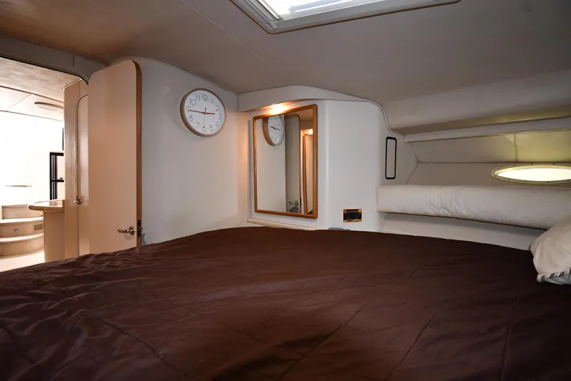 Slide: The Image of Interior cabin of 1997 Sea Ray 400 Sundancer with bed, clock, and mirror. - 34
