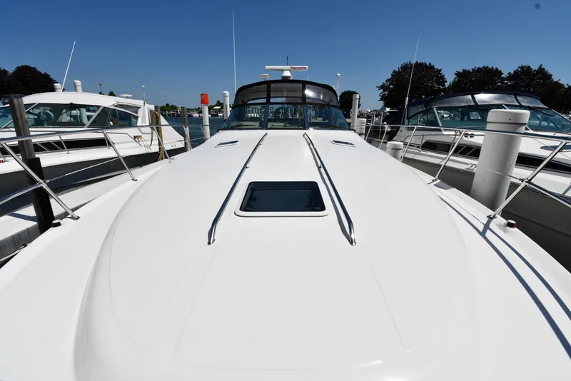 Slide: The Image of 1997 Sea Ray 400 Sundancer yacht docked at marina under clear blue sky. - 4