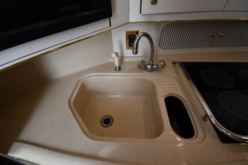 Slide: The Image of Kitchen sink and stovetop in 1997 Sea Ray 400 Sundancer yacht galley. - 46