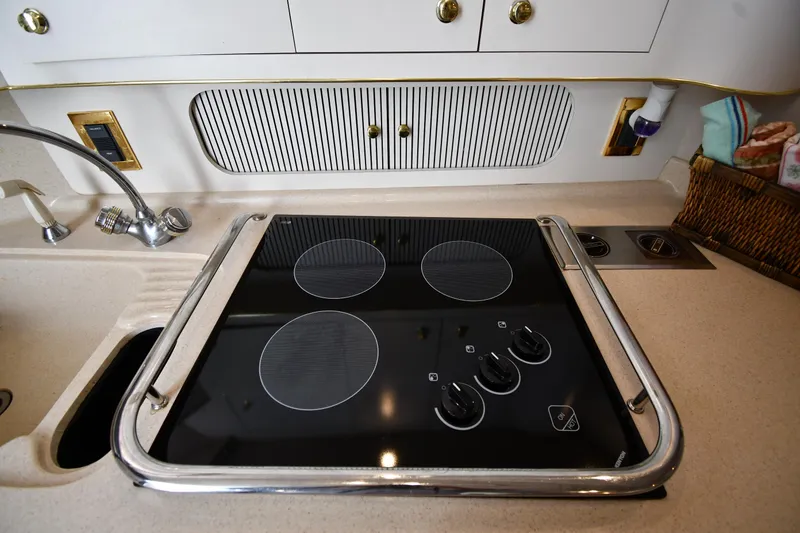 Slide: The Image of 1997 Sea Ray 400 Sundancer kitchen with stovetop and sink. - 47