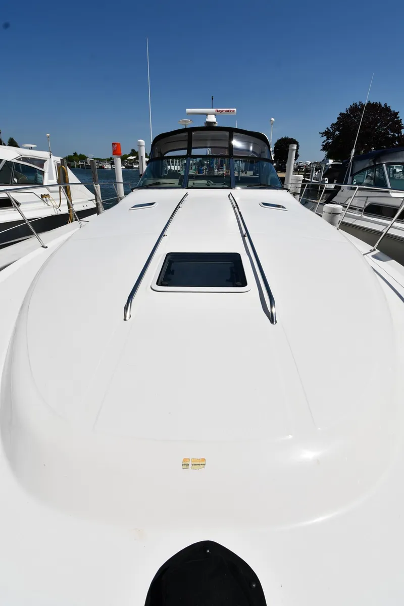 Slide: The Image of 1997 Sea Ray 400 Sundancer yacht docked, showcasing sleek white deck design. - 5