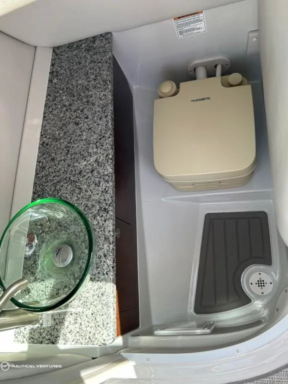 Slide: The Image of 2024 Crownline E290 XS boat bathroom with granite countertop and portable toilet. - 12