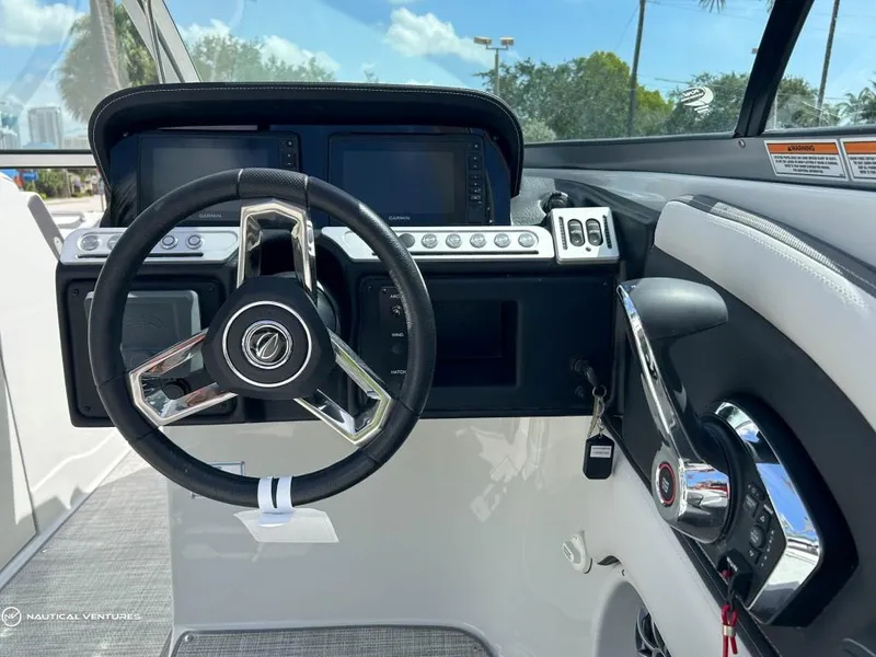 Slide: The Image of 2024 Crownline E290 XS boat dashboard with steering wheel and control panel. - 3